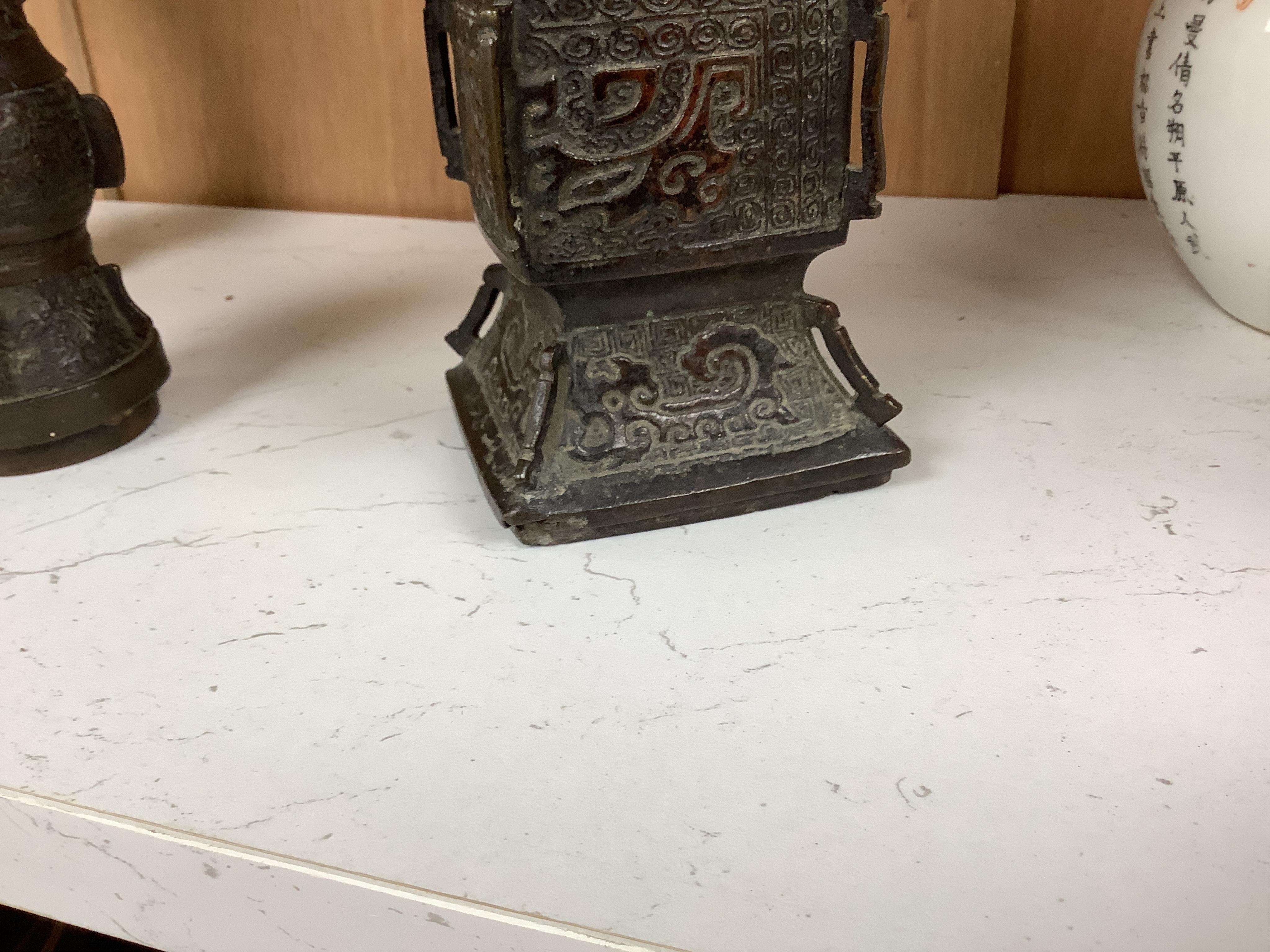 A pair 17th/18th century Chinese archaistic bronze gu vases, and a similar square vase, fanggu, Ming dynasty, tallest 18cm. Condition - poor to fair